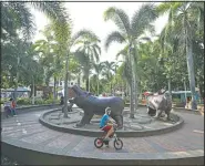  ??  ?? A boy rides his bicycle in a park decorated with hippo statues in Doradal, Colombia.