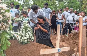  ?? CARL COURT/GETTY IMAGES ?? Mourners grieve for one of the people killed in the Easter Sunday attack on St.Sebastian’s Church in Negombo, Sri Lanka.