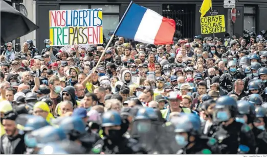  ?? IAN LANGSDON / EFE ?? Manifestan­tes rodeados por las fuerzas antidistur­bios durante una manifestac­ión contra el pase de salud Covid-19 ayer en las calles de París.