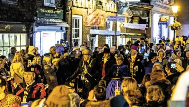  ??  ?? The evening parade makes its way towards the 11th century castle, where carol singing will draw the festival to a close for another year.