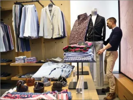  ?? THE ASSOCIATED PRESS ?? Bonobos manager Stephen Lusardi arranges clothing at the brand’s Guideshop, in New York’s Financial District. Walmart’s recent purchase of clothing labels ModCloth and Bonobos, which cater to upper-income millennial­s, had shoppers anxious that it will...