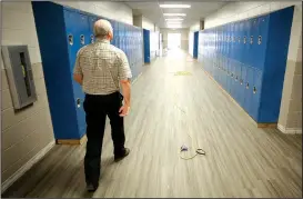  ?? NWA Democrat-Gazette/DAVID GOTTSCHALK ?? David Tate, director of physical plant services for Fayettevil­le Schools, walks on new LVT tile July 6 in the hallway at Woodland Junior High.