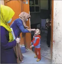  ?? Rahmat Gul Associated Press ?? HEALTH WORKERS administer the oral polio vaccine to a child in Kabul, Afghanista­n, in March 2021.