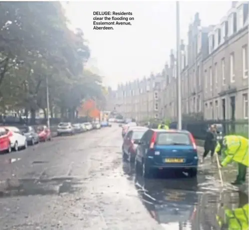  ??  ?? DELUGE: Residents clear the flooding on Esslemont Avenue, Aberdeen.