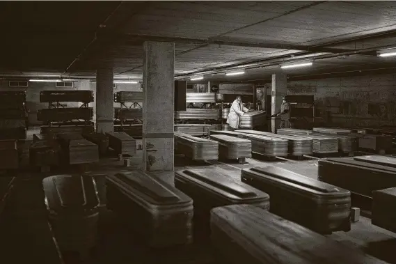  ?? Felipe Dana / Associated Press ?? Coffins of those who died of COVID-19 are stored in an undergroun­d parking lot as they await burial in April at the Collserola funeral home in Barcelona, Spain.