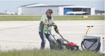  ?? NICK BRANCACCIO ?? Windsor Internatio­nal Airport director of operations Steve Tuffin tackles the lawn at YQG on Tuesday as the airport continues to deal with industry shutdowns and reduced services due to the COVID-19 crisis.