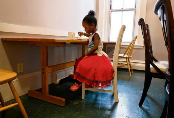  ?? SUZANNE KREITER/GLOBE STAFF ?? Three-year-old Smaelle ate breakfast in the overflow shelter run by Catholic Charities Boston.