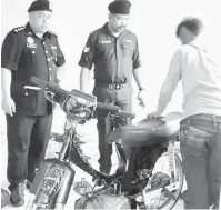  ??  ?? PERIKSA: Johny dan Norhasmadi memeriksa motosikal disyaki dicuri yang dileraikan oleh remaja tersebut.
