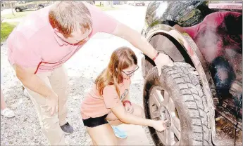  ?? RACHEL DICKERSON/MCDONALD COUNTY PRESS ?? Teacher Jeremy Whittle (left) helps eighth-grader Danielle Patterson change a truck tire during a life skills class at Pineville Elementary School on Oct. 1.