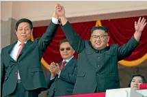  ?? AP ?? North Korean leader Kim Jong Un, right, raises hands with China’s third highest ranking official, Li Zhanshu, during a parade for the 70th anniversar­y of North Korea’s founding day in Pyongyang.