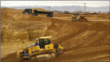  ?? RACHEL ELLIS — THE DENVER POST ?? Trucks drive dozens of feet above where there was once a home belonging to Julie and Mark Nygren at the intersecti­on of Weld County roads 13 and 42 in Johnstown in 2021.