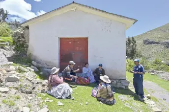  ?? ?? Aguilar (centre), shares an “ajtapi” (communal meal) with family members in the community of Chachapoya on the shores of Lake Titicaca, in the Bolivian highlands.