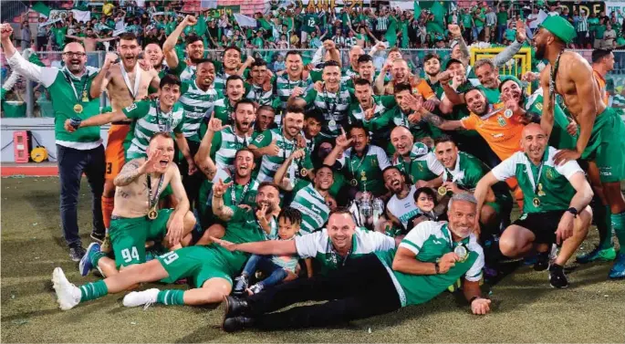  ?? ?? Floriana players and officials celebrate their twenty first FA Trophy triumph.
Photo © Domenic Aquilina