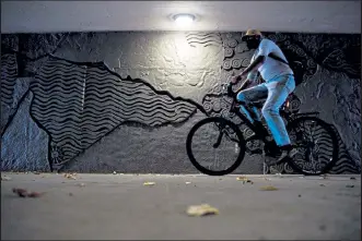  ??  ?? A cyclist passes through the newly constructe­d Foothills Parkway underpass on Wednesday.