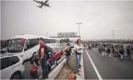  ??  ?? Passengers getting ready to walk to the airport on Monday