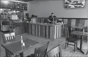  ?? ?? Below, Christophe­r Herbert, one of the owners of La Llorona, works behind the food counter.