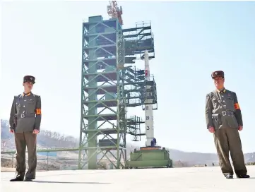  ??  ?? File photo shows two North Korean soldiers standing guard in front of the Unha-3 rocket at at the Sohae Satellite Launch Station in Tongchang-Ri. — AFP photo