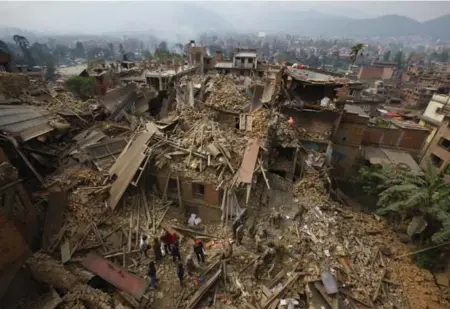  ?? NIRANJAN SHRESTHA/THE ASSOCIATED PRESS ?? Rescuers are dwarfed by rubble as they search for earthquake victims in Bhaktapur, near Kathmandu, on Sunday. More than 3,200 people have died.