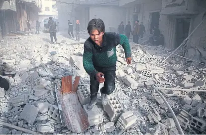  ?? Amer almohibany/aFP ?? Un joven sirio huye durante el ataque norteameri­cano en Ghouta Oriental