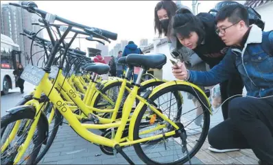  ?? CANG HAI / FOR CHINA DAILY ?? Riders scan ofo bikes in Xi’an, Shaanxi province. The bike-hire startup is experiment­ing with a deposit waiver system for users in Shanghai and may extend the service to other cities in the country.