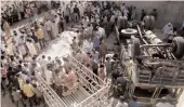  ?? — PTI ?? Police personnel and people gather around a vehicle which is seen lying turtle after it fell into a drain in Bhavnagar, Gujarat, on Tuesday.