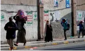  ?? — AFP ?? A family carries their belongings as it flees an area in the Yemeni capital Sanaa on Sunday.