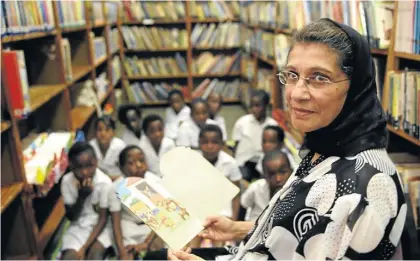  ?? Picture: TEBOGO LETSIE ?? DEDICATED: Hasinah Goga with pupils and some of the thousands of books