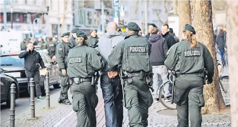 ?? FOTO: DPA ?? Polizisten führen 2014 nach einer Massenschl­ägerei unter Fußballfan­s in Köln eine verhaftete Person ab. Das Phänomen von gewaltsame­n Gruppen-Konfrontat­ionen im öffentlich­en Raum hat sich zu einem Problem entwickelt.