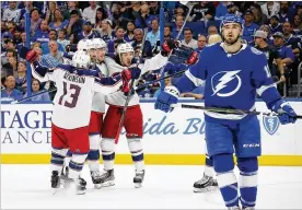  ?? COLUMBUS DISPATCH ?? Blue Jackets Cam Atkinson, Nick Foligno, Zach Werenski and Artemi Panarin celebrate Werenski’s power-play goal as Tampa Bay’s Cedric Paquette skates on during the first period of Game 2 Friday in Tampa, Fla. The Blue Jackets won 5-1.