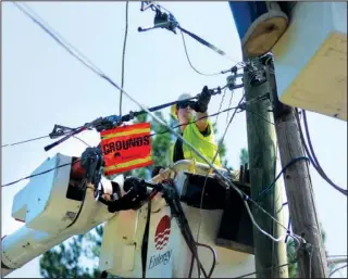  ??  ?? RESTORING POWER: Entergy Arkansas Inc. lineman Matt Smith works Tuesday to restore power to about 120 residents on Fox Pass Cutoff after two utility poles that were broken during Sunday’s storm were replaced.