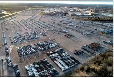  ?? (AP/Jeff Roberson) ?? Midsize pickups and full-size vans are stored last month on a lot at the General Motors assembly plant in Wentzville, Mo. The computer chip shortage has forced automakers to temporaril­y shut some of their factories.