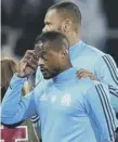 ??  ?? 0 Patrice Evra is ushered away by a team- mate