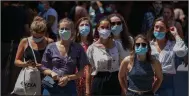  ??  ?? Tourists wait to cross a road Thursday in downtown Barcelona, Spain. On the Spanish island of Mallorca, bars in an area known as a party hub were ordered shut down to fight the spread of the coronaviru­s.
(AP/Emilio Morenatti)