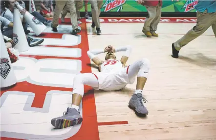  ?? CRAIG FRITZ/FOR THE NEW MEXICAN ?? New Mexico’s Anthony Mathis falls to the ground as staff rush the floor to break up a fight at the end of Tuesday’s 71-73 loss to Boise State in The Pit in Albuquerqu­e.