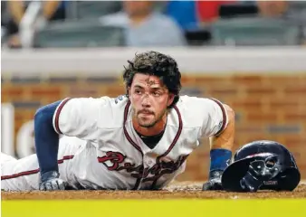  ?? AP PHOTO BY JOHN BAZEMORE ?? The Atlanta Braves’ Dansby Swanson lies on the ground after being hit by a pitch from Boston Red Sox starting pitcher Rick Porcello in the second inning Tuesday in Atlanta. Swanson left the game.