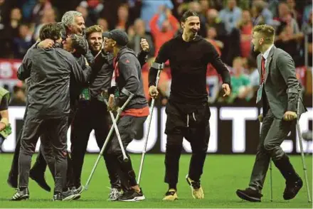  ?? EPA PIC ?? Manchester United manager Jose Mourinho celebrates with his staff and injured players Luke Shaw (right), Zlatan Ibrahimovi­c (second from right) and Ashley Young in Stockholm on Wednesday.