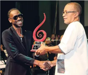  ?? PHOTO BY LEON HUDSON ?? Bounty Killer (left) collects his award from mentorship from Mikey Bennett at the 11th annual Jamaica Reggae Industry Associatio­n (JARIA) Honour Awards in Kingston on Sunday.