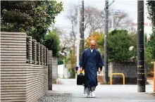  ??  ?? Buddhist monk Kaichi Watanabe walking to a home to commemorat­e the oneyear anniversar­y of a woman's death in Funabashi, Chiba prefecture, a suburb of Tokyo. — AFP photos