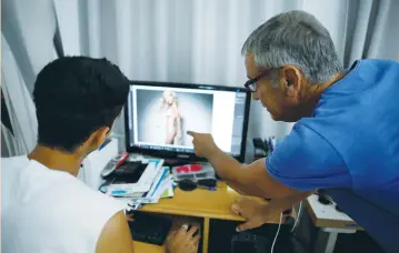  ??  ?? ADI BARKAN (right), who runs campaigns promoting healthy and realistic fashion standards, and another Israeli photograph­er demonstrat­e the post-production editing process of a photo shoot set up for Reuters at Barkan’s studio in Tel Aviv last month.