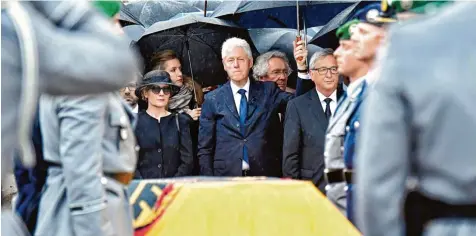  ?? Foto: Tobias Schwarz, afp ?? Nach der Trauermess­e im Dom zu Speyer wird Helmut Kohl mit einem großen militärisc­hen Ehrengelei­t verabschie­det. Hinter dem mit der bundesdeut­schen Flagge bedeckten Sarg stehen (von links) Witwe Maike Kohl Richter, der ehemalige US Präsident Bill...