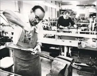  ?? Hearst Connecticu­t Media file photos ?? Men repair model 94 guns in the product services department at U.S. Repeating Arms Co. The photo is dated November 1990.