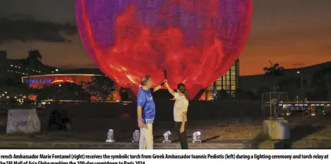  ?? ?? French Ambassador Marie Fontanel (right) receives the symbolic torch from Greek Ambassador Ioannis Pediotis (left) during a lighting ceremony and torch relay at the SM Mall of Asia Globe marking the 100-day countdown to Paris 2024.