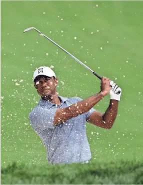  ??  ?? Tiger Woods watches his ball after hitting from a sand trap Wednesday on the 14th hole during the pro-am round of the BMW Championsh­ip.