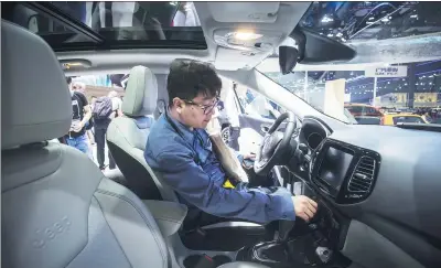  ?? BLOOMBERG ?? A visitor sits inside a Fiat Chrysler Automobile­s NV Jeep Compass sport utility vehicle, manufactur­ed by Guangzhou Automobile Group Co, on display at the China (Guangzhou) Internatio­nal Automobile Exhibition in Guangzhou on Nov 19, 2016.