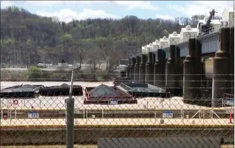  ?? WTAE TV ?? LEFT: A group of barges sits pinned against the Emsworth lock and dam on Saturday in Pittsburgh. More than two dozen river barges broke loose from their moorings and floated down the Ohio River, damaging a marina and striking a bridge.