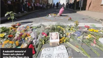  ?? | STEVE HELBER/ AP ?? A makeshift memorial of flowers and a photo of victim Heather Heyer sits in Charlottes­ville, Virginia, on Sunday.