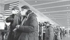  ?? STEVEN SENNE/ AP ?? Travelers wait at Logan Internatio­nal Airport in Boston before Thanksgivi­ng. On Monday, travel from some African nations was banned.