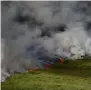  ?? Reuters ?? Smoke rises from scorched moorland as it burns during a moorland fire at Winter Hill, on Sunday. —