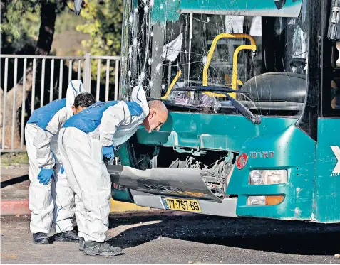  ?? ?? Forensic experts work at the scene of one of two explosions that targeted bus stations in Jerusalem, in the first bomb attack on Israeli civilians for six years