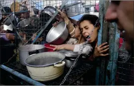  ?? MAHMOUD ESSA — THE ASSOCIATED PRESS ?? Palestinia­ns line up for free food at Jabaliya refugee camp in the Gaza Strip on March 18.